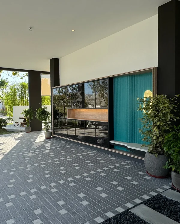 Covered entrance porch at Bungalow Dees with a teal fluted door panel and tiled driveway