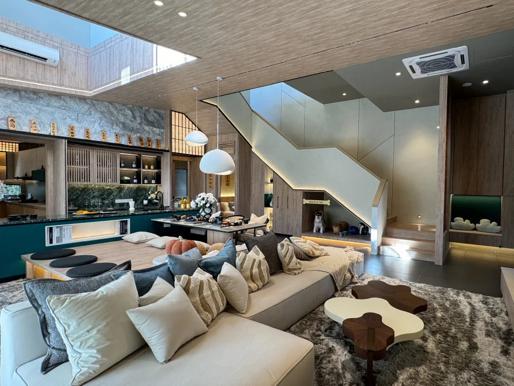 Double-height living hall at Bungalow Dees with warm timber ceiling, deep green kitchen cabinetry and a sunken lounge