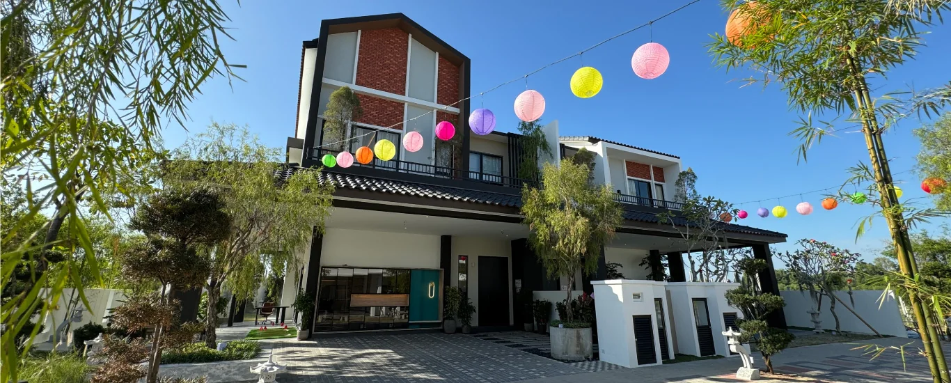 Street view of completed Bungalow Dees homes with festive lanterns strung between trees